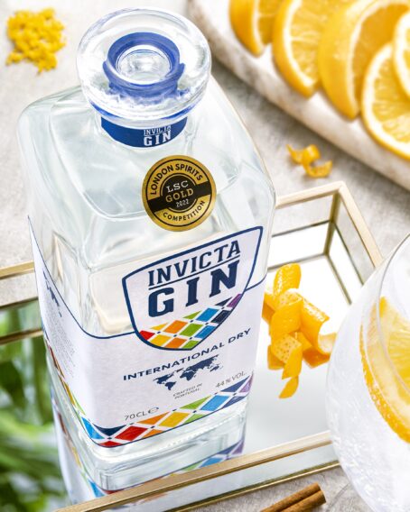 Invicta Gin bottle on a mirror surrounded by orange peels